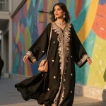 Elegant woman in embroidered abaya twirls in urban setting, showcasing modern fashion.